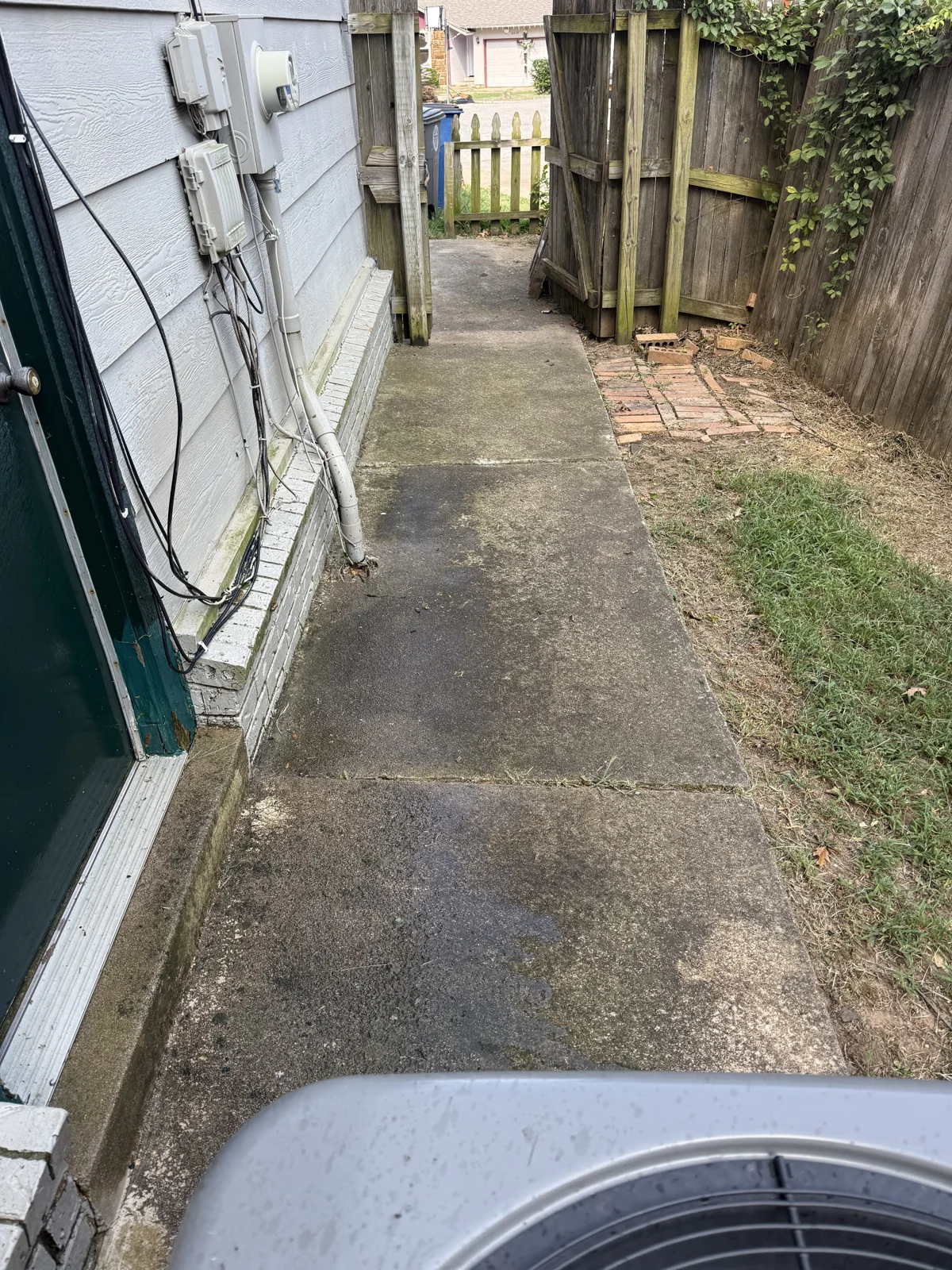 Dark buildup on a narrow concrete passage before cleaning